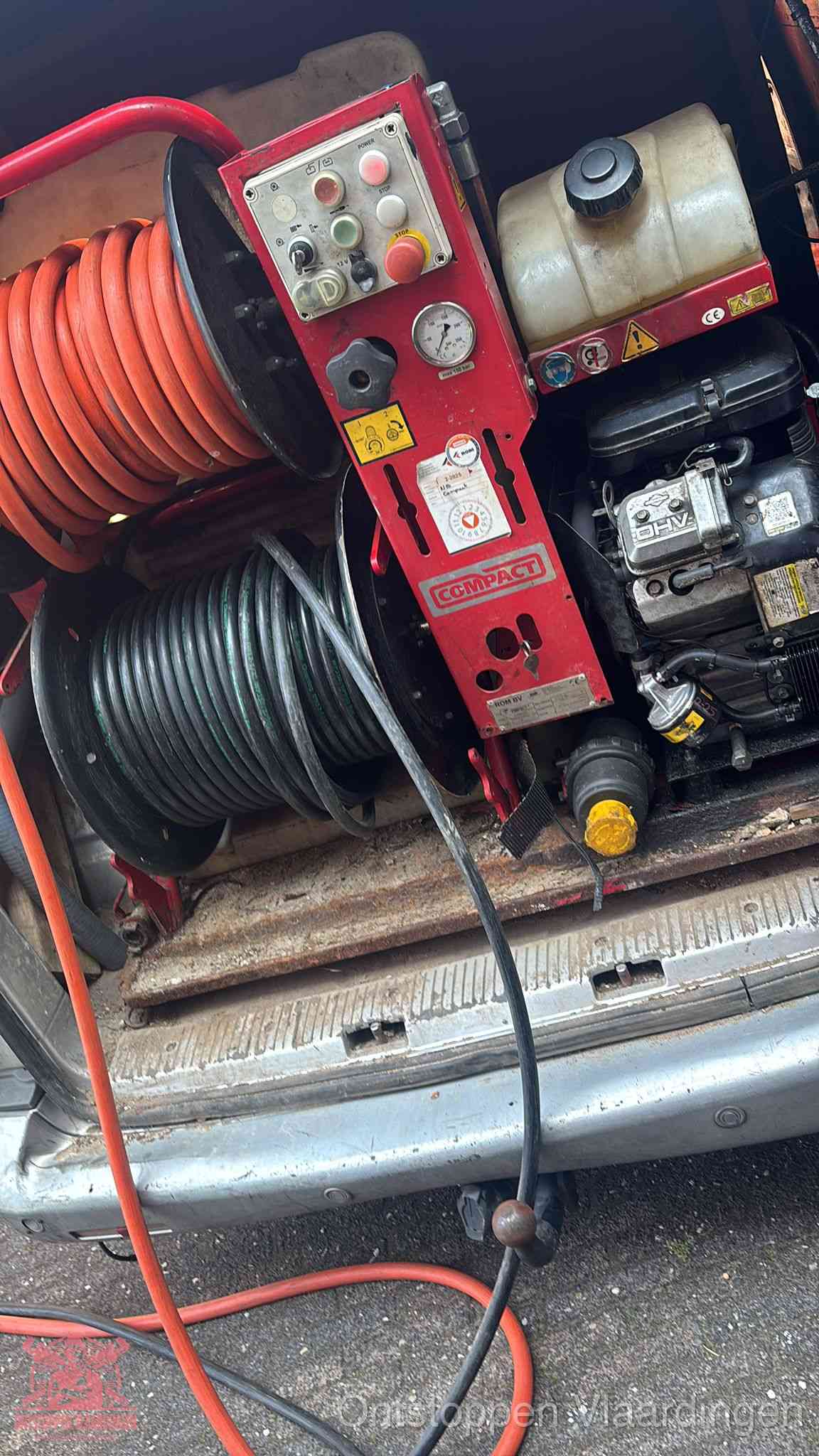 Een rood hogedruk-rioolreinigingstoestel met slangen in de laadbak van de bedrijfsbus, apparatuur voor een hardnekkige wc-verstopping in Vlaardingen