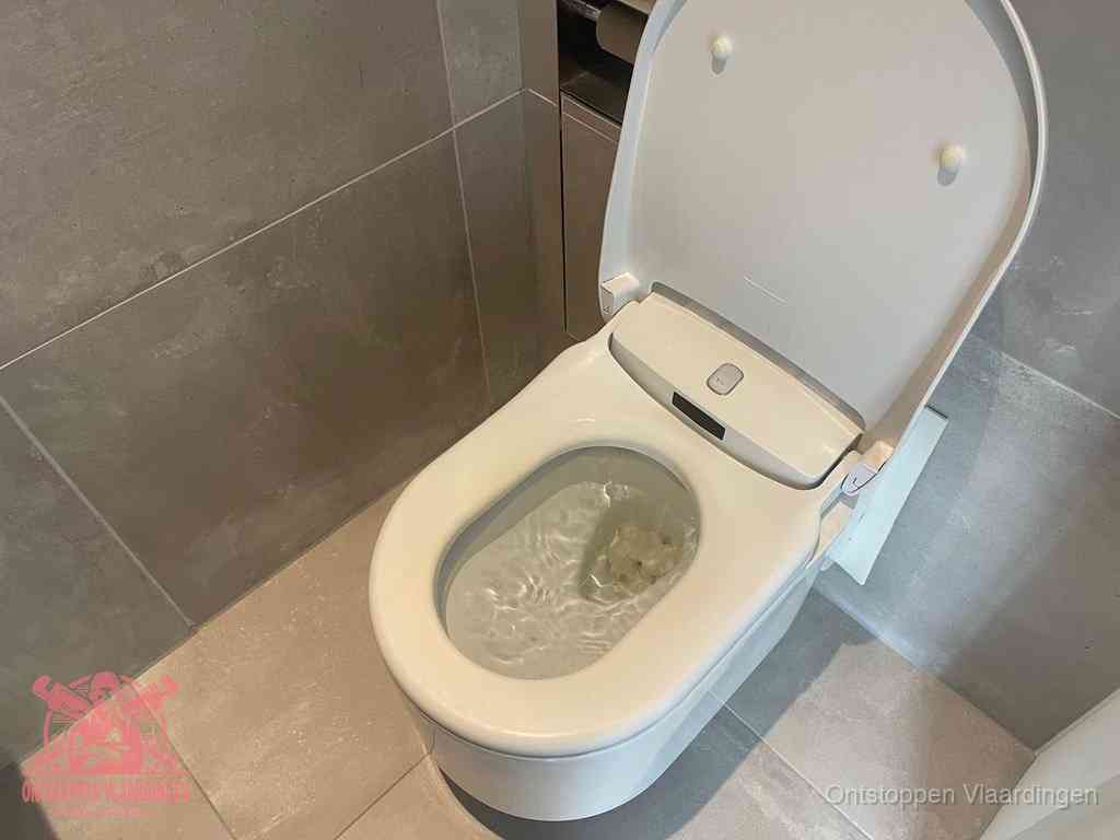 Een toiletpot vol troebel water met drijvend papier en restanten, de meest voorkomende oorzaak van een verstopte wc in Vlaardingen