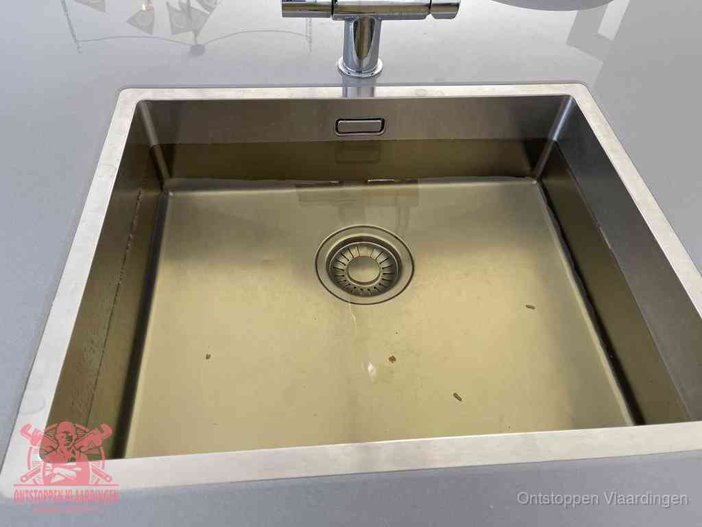 Stilstaand water in een rvs spoelbak dat niet wegloopt, een duidelijk signaal van een gootsteenverstopping in Vlaardingen